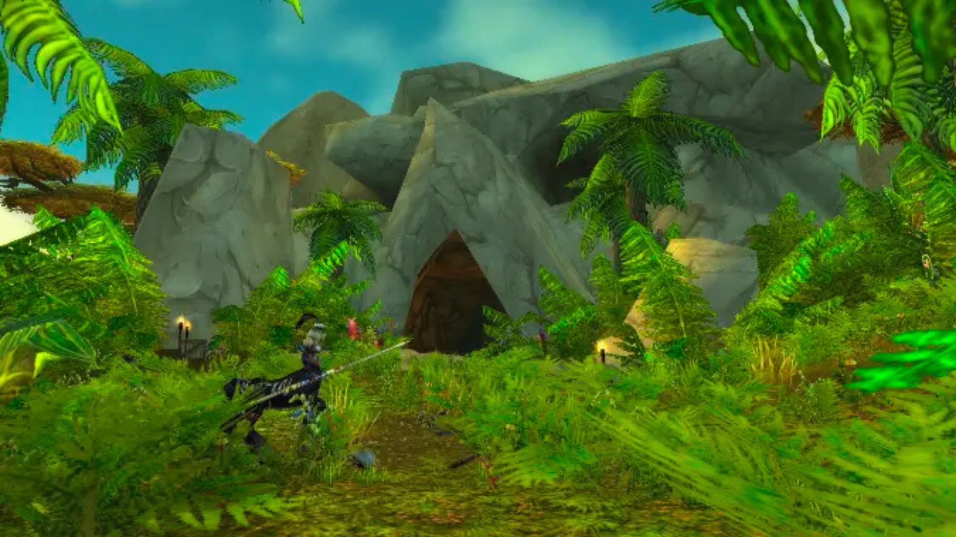 "World of Warcraft screenshot of a jungle with palm trees and rocks, showing a player on a skeletal horse mount near a cave entrance."