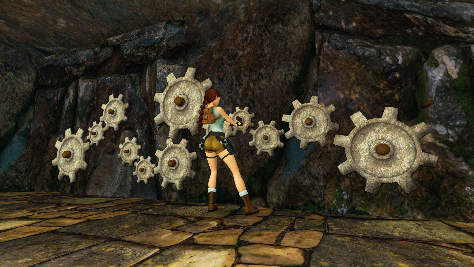 Lara solves a gear puzzle in a stone chamber, showcasing updated visuals in Tomb Raider Remastered.