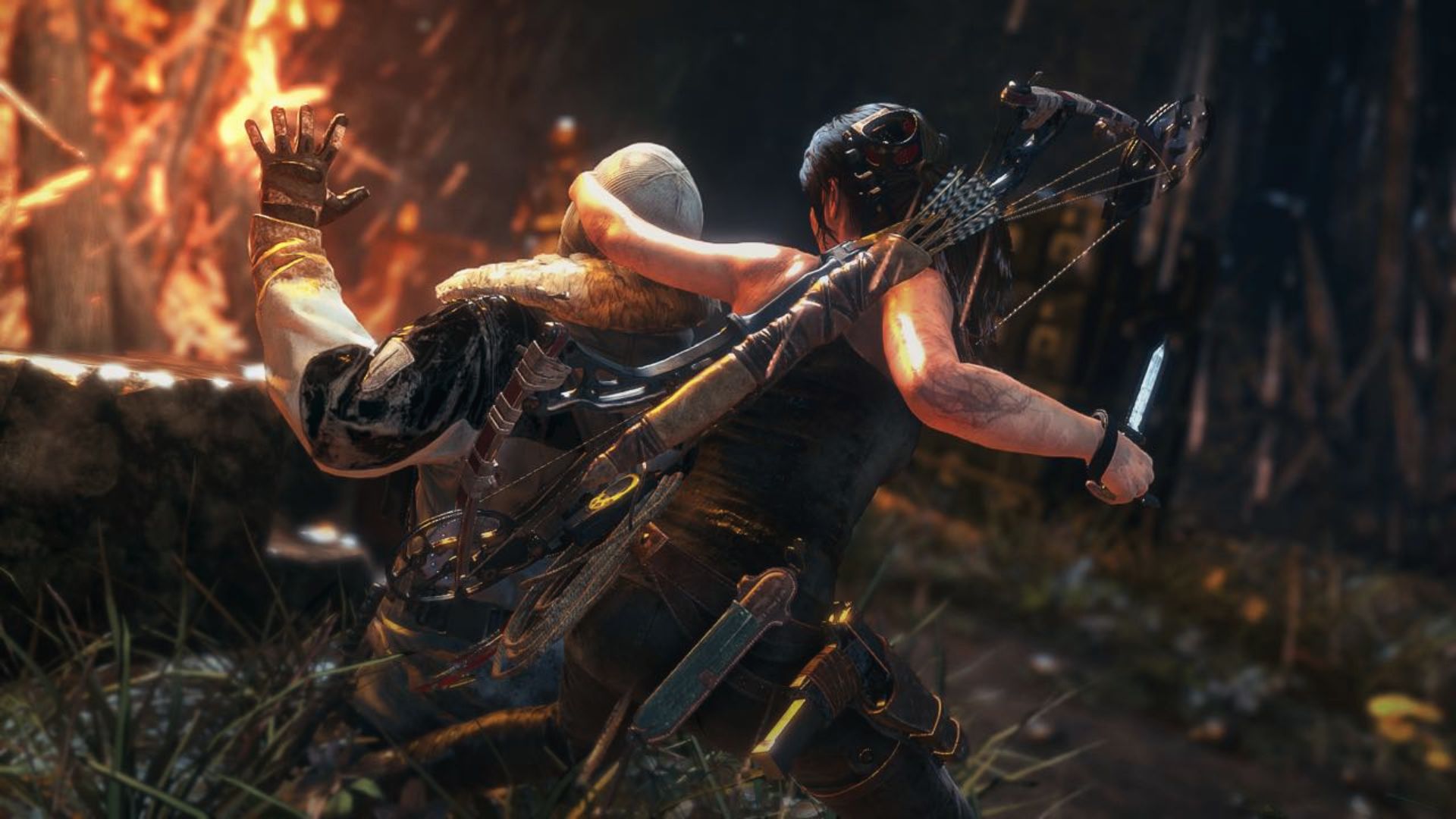 Lara stealth kills the enemy with a knife amid flames. Rise of the Tomb Raider upgrades brutal combat flow.