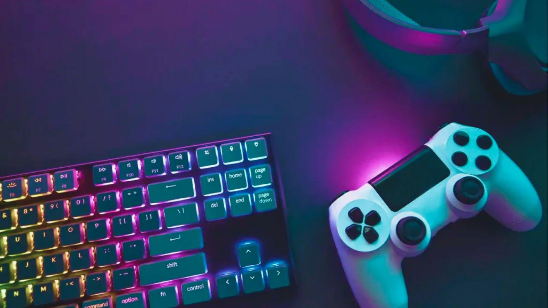 Overhead view of a white controller and mechanical keyboard bathed in pink and blue RGB.