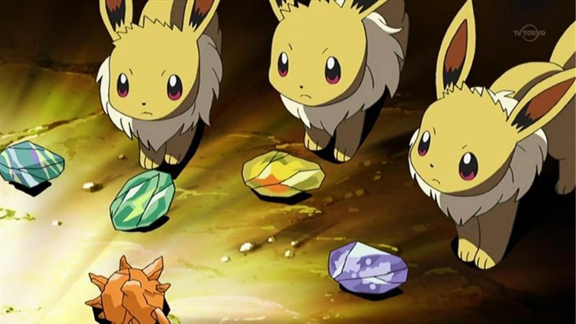 Three worried Eevee anime characters examine colorful evolution stones including Fire, Water, Leaf, Thunder, and Shiny stones on the cave floor.