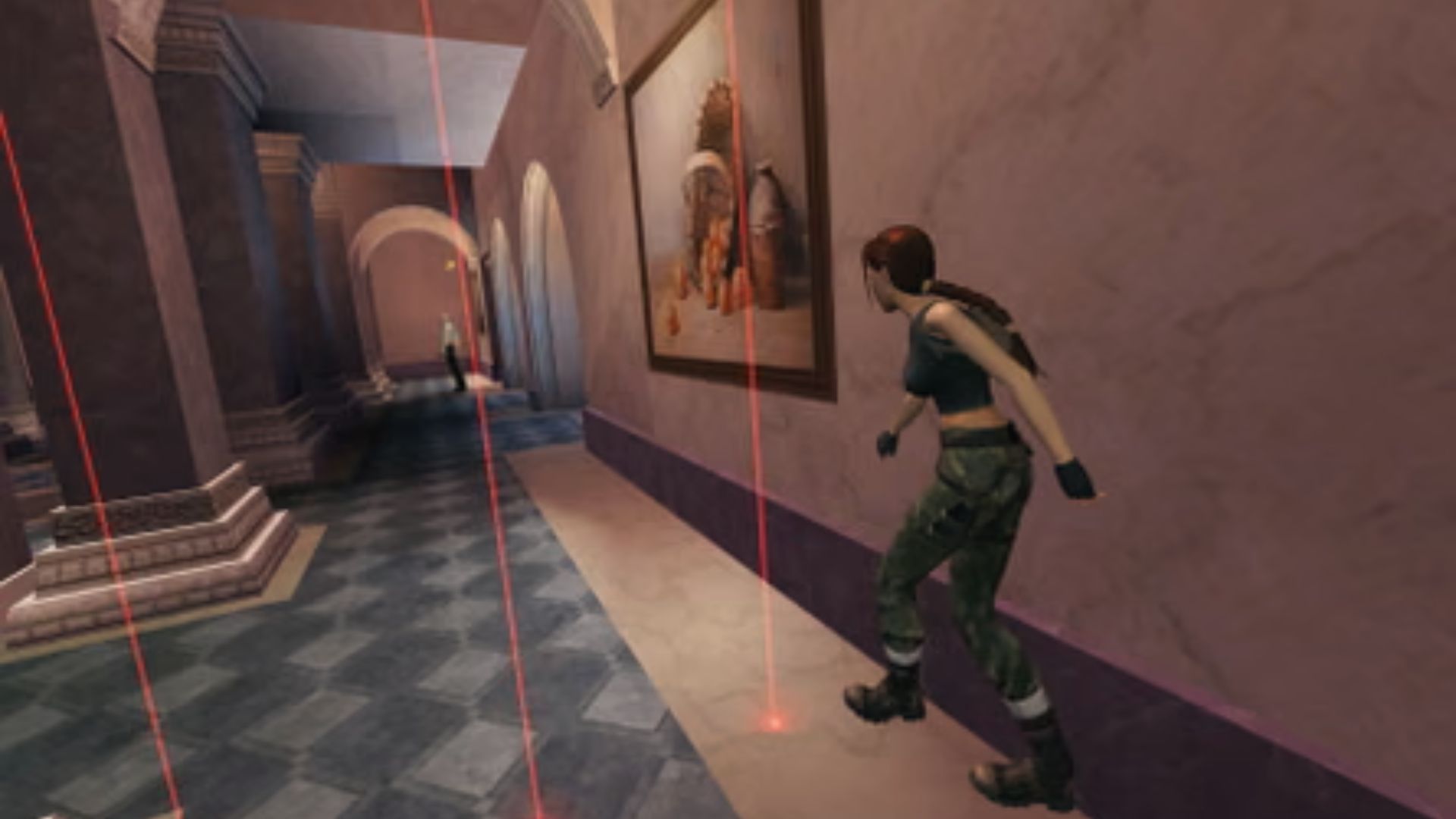 Lara Croft sneaks through a museum hall dodging red laser traps in Tomb Raider Remastered on Switch.