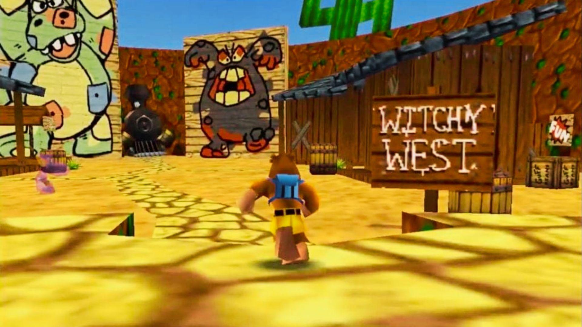Banjo-Tooie gameplay in Witchywest area showing Banjo with backpack walking toward wooden sign, cartoon western buildings, train