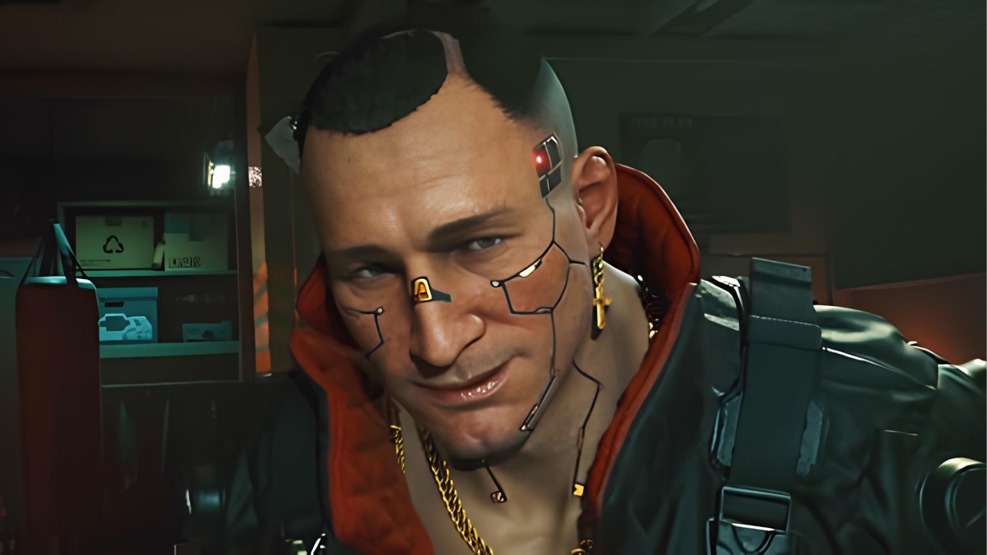 Jackie Welles with mohawk, facial cyberware lines, gold cross earring, and chains smirks in red hoodie under black leather jacket.