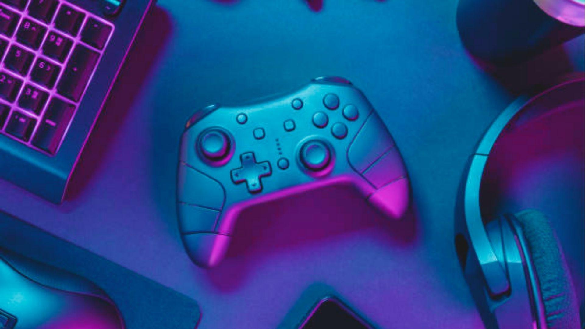 Flat lay of essential gaming gear: controller, headset, and RGB keyboard under neon lighting.